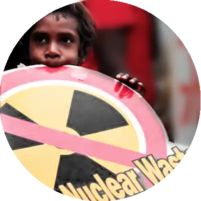Aboriginal boy holding up a no nuclear waste placard