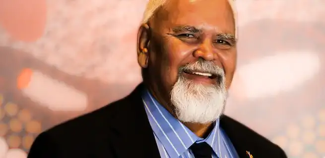 Tauto Sansbury wearing a suit and smiling